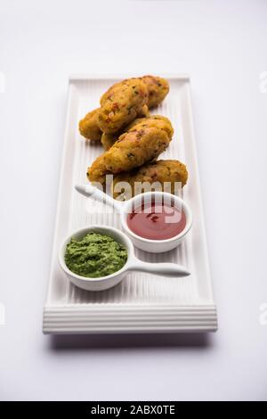 Gemüse Poha Schnitzel oder abgeflachte Reispasteten serviert mit Tomatenketchup und grünem Chutney Stockfoto