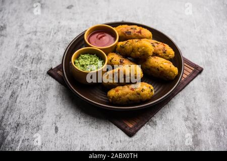 Gemüse Poha Schnitzel oder abgeflachte Reispasteten serviert mit Tomatenketchup und grünem Chutney Stockfoto