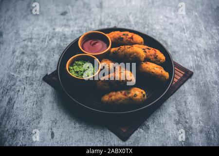 Gemüse Poha Schnitzel oder abgeflachte Reispasteten serviert mit Tomatenketchup und grünem Chutney Stockfoto