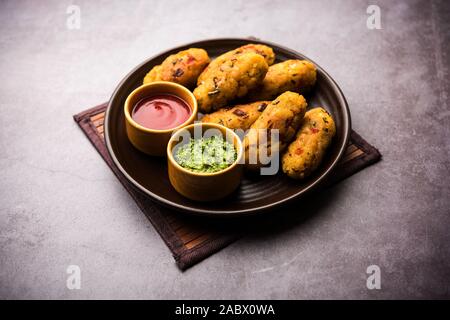 Gemüse Poha Schnitzel oder abgeflachte Reispasteten serviert mit Tomatenketchup und grünem Chutney Stockfoto