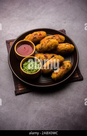 Gemüse Poha Schnitzel oder abgeflachte Reispasteten serviert mit Tomatenketchup und grünem Chutney Stockfoto