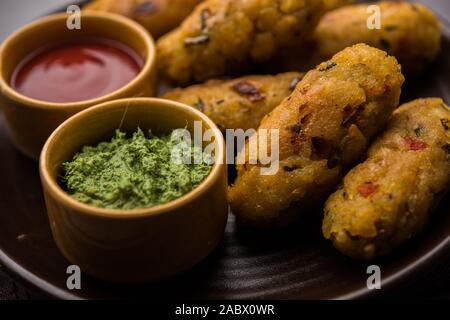 Gemüse Poha Schnitzel oder abgeflachte Reispasteten serviert mit Tomatenketchup und grünem Chutney Stockfoto