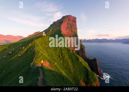 Kallur Leuchtturm auf grünen Hügeln der Insel Kalsoy, Färöer, Dänemark. Landschaftsfotografie Stockfoto