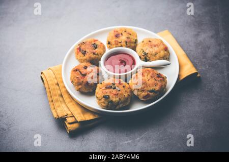 Gemüse Poha Schnitzel oder abgeflachte Reispasteten serviert mit Tomatenketchup und grünem Chutney Stockfoto