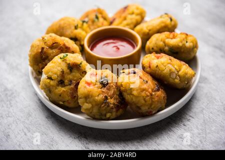 Gemüse Poha Schnitzel oder abgeflachte Reispasteten serviert mit Tomatenketchup und grünem Chutney Stockfoto