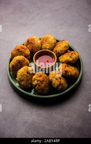 Gemüse Poha Schnitzel oder abgeflachte Reispasteten serviert mit Tomatenketchup und grünem Chutney Stockfoto