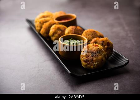 Gemüse Poha Schnitzel oder abgeflachte Reispasteten serviert mit Tomatenketchup und grünem Chutney Stockfoto
