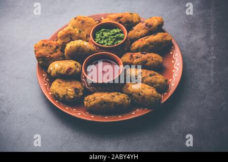 Gemüse Poha Schnitzel oder abgeflachte Reispasteten serviert mit Tomatenketchup und grünem Chutney Stockfoto