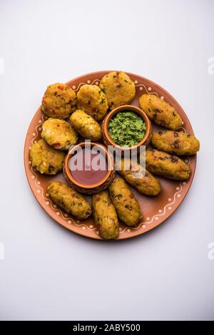 Gemüse Poha Schnitzel oder abgeflachte Reispasteten serviert mit Tomatenketchup und grünem Chutney Stockfoto