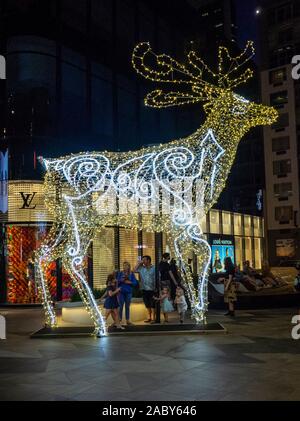 Familie stehen unter Weihnachtsbeleuchtung Riese Rentiere in das Raine Square Perth Western Australia. Stockfoto