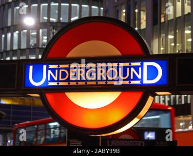 TfL London U-Bahn-Schild im alten Stil, in der Abenddämmerung in der City of London, Bank Tube Station, City of London Financial District hinter, England, Großbritannien Stockfoto