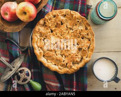 Selbstgebackenen Apfelkuchen mit einem Glas Milch auf einem urigen Hintergrund. Stockfoto
