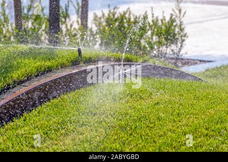 Sprinkleranlage, Bewässerung park Rasen mit Hintergrund des grünen Grases. Stockfoto