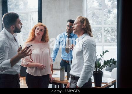 Kurzhaariger Mann mit Stift in der Hand in der klassischen tragen erklärt Business Plan Stockfoto