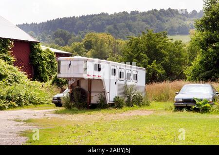 Eine verlassene Fifth Wheel Trailer und andere Fahrzeuge im ländlichen New York State, USA. Stockfoto