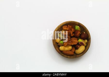 Auswahl der Walnüsse, Haselnüsse, cashew Nüsse und Mandeln in Miniatur Bambus Schale auf der weißen Fläche mit Kopie Raum Stockfoto