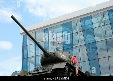 Charkow, Ukraine - Juni 21, 2019: Ein gepanzerter Tank in Platz der Verfassung. Das Kind kletterte in den Tank. Kinder spielen und kletterten auf den Tank. Stockfoto