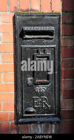 Schwarz Post Box an einer Wand in Whitby, North Yorkshire. Stockfoto