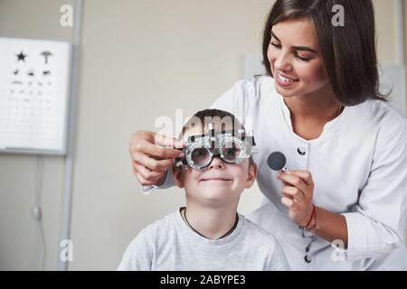 Die Augen weit geöffnet. Arzt tuning Der phoroptor an Sehschärfe des kleinen Jungen bestimmen Stockfoto