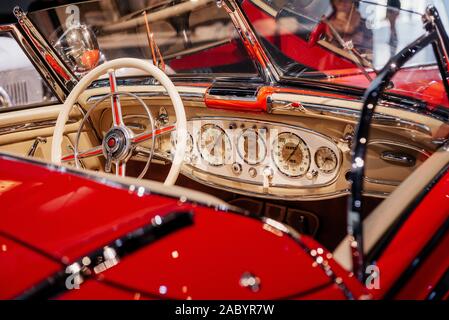 Red vintage Automobile. Armaturenbrett, Lenkrad, und die vorderen Gläser von hinten erfasst Stockfoto