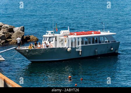 Hafen der alten Tellaro Dorf mit einer Fähre mit einigen Touristen. Mittelmeer, Golf von La Spezia, Ligurien, Italien, Europa Stockfoto