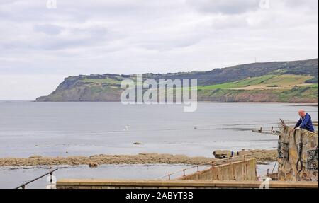 Man blickte nach unten am Strand. Schwinden die Gezeiten. Robin Hood's Bay. Aus dem Meer an der Wand. Stockfoto