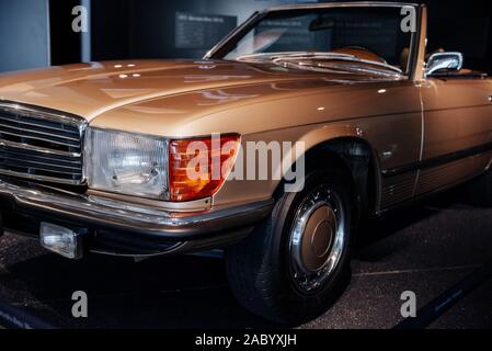 Nahaufnahme der vorderen und seitlichen Blick auf den linken Scheinwerfer mit den Zeichen der retro beige Cabrio Auto mit verchromten Kühler, Stoßfänger, Festplatte und Leichtmetall. Stockfoto