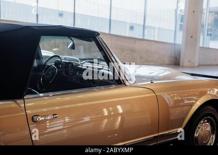 Seitenansicht des beige retro Cabrio Auto mit Lenkrad, vorne rechts Chrom disc, Verkleidung und Türgriff, Bogen über einen Reifen innen Stockfoto