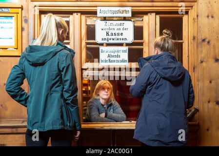 Zwei weibliche Bergwanderer mit einer Frau an der Rezeption der Berliner Hütte, Zillertal, Tirol, Österreich Stockfoto