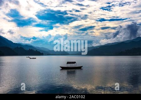 Eine einzelne Zeile Boot in der Mitte des Phewa-see und Wolken am Himmel Hintergrund geparkt, Pokhara Nepal Stockfoto