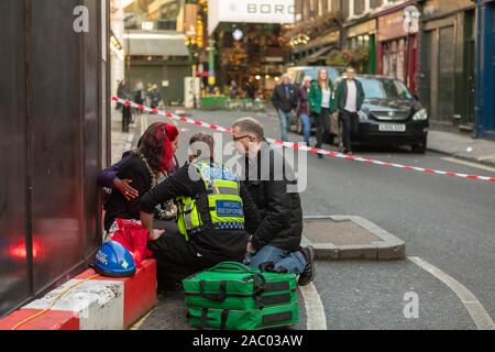 Borough Market, London, Großbritannien. November 2019. Die Rettungsdienste reagierten auf einen Messerstecher auf der London Bridge und veranlassten eine von der Polizei geführte Evakuierung in der Nähe des Borough Market. Das Bild zeigt Sanitäter, die einen verletzten Fußgänger in einem abgesperrten Bereich betreuen, während die Polizei die Umgebung absichert. Der Vorfall, der als Terrorismus behandelt wurde, störte das geschäftige Marktviertel und zog eine bedeutende Notfallreaktion nach sich. Penelope Barritt/Alamy Live News Stockfoto