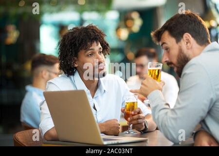 Junge Unternehmer Standortwahl Pub und trinken Bier, als Sie arbeiten Stockfoto