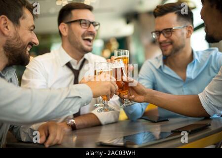 Geschäftsleute sitzen in der Kneipe und trinken Bier nach der Arbeit Stockfoto