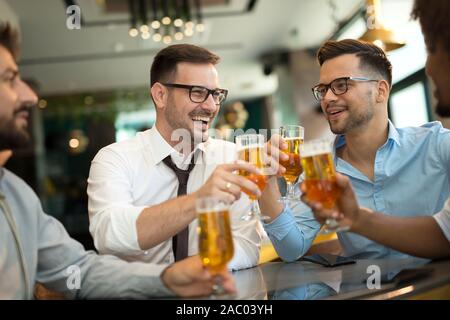 Geschäftsleute sitzen in der Kneipe und trinken Bier nach der Arbeit Stockfoto