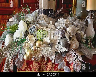 Üppige überhängenden Weihnachten Dekoration in einer Shell in Silbrigen Farbtönen und Perlmutt mit Kugeln, weiße Rosen, silbrigen Blätter, Gräser und Hellgrün Stockfoto