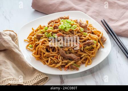 Essen chinesisch Rindfleisch lo mein Nudeln mit Stäbchen Stockfoto