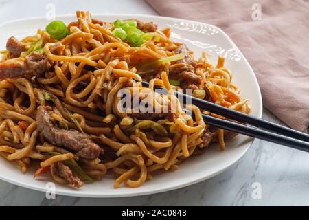 Essen chinesisch Rindfleisch lo mein Nudeln mit Stäbchen Stockfoto