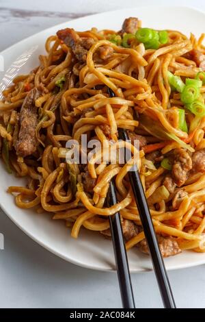 Essen chinesisch Rindfleisch lo mein Nudeln mit Stäbchen Stockfoto