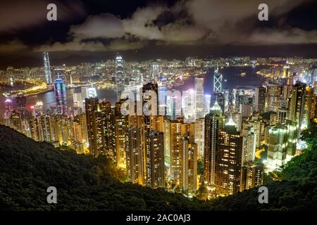 Nachtansicht auf Hongkong vom Victoria Peak. Touristen besuchen die Skyline. Stockfoto