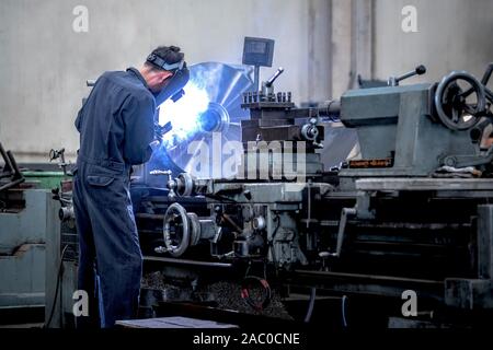 Arbeitnehmer ist Fräsen von Metall Teile mit Drehmaschinen mit hoher Präzision im Prozess der Arbeit, der Herstellung von industriellen. Stockfoto