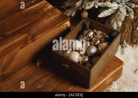 Christbaumschmuck in ein Feld in einem hölzernen Tisch. Holzkiste mit Weihnachtsschmuck gefüllt. Weihnachten. Stockfoto