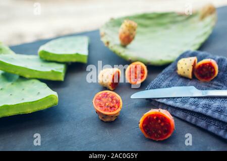 Feigenkaktus oder kaktusfrüchte Schnitt mit Blättern. Exotische gesundes Essen auf grauem Hintergrund. Stockfoto
