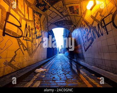 Man Walking in einer Gasse der weißen Kapelle Bezirk Stockfoto