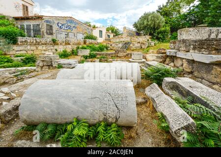 Antiken Säulen mit Inschriften neben einem neuen Gebäude mit Graffiti in Athen, Griechenland. Stockfoto