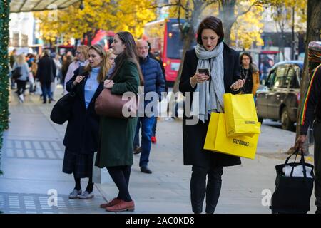 London, Großbritannien. 29 Nov, 2019. Ein Käufer trägt Selfridges Einkaufstasche in der Oxford Street während er Schwarzer Freitag. Schwarzer Freitag ist ein Shopping Event in dem Einzelhändler die Preise am Tag nach Thanksgiving, die aus den USA stammt. Quelle: Steve Taylor/SOPA Images/ZUMA Draht/Alamy leben Nachrichten Stockfoto