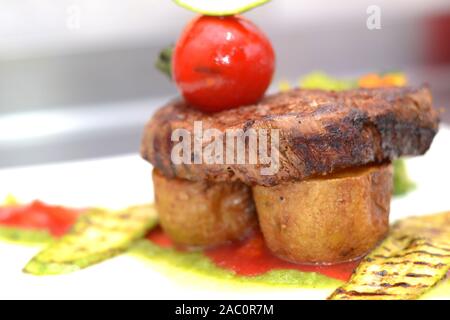 Küchenchef Bonfile Steak braten Kartoffel mit Salat, gerösteten Gemüsegarnitur und brocolli Brei Stockfoto