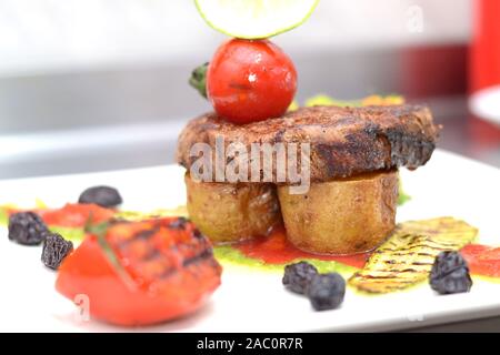 Küchenchef Bonfile Steak braten Kartoffel mit Salat, gerösteten Gemüsegarnitur und brocolli Brei Stockfoto