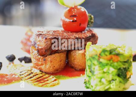 Küchenchef Bonfile Steak braten Kartoffel mit Salat, gerösteten Gemüsegarnitur und brocolli Brei Stockfoto