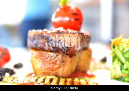 Küchenchef Bonfile Steak braten Kartoffel mit Salat, gerösteten Gemüsegarnitur und brocolli Brei Stockfoto