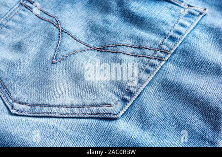 Textur der blauen Jeans Stoff mit Tasche auf der Rückseite und Stickerei Stockfoto